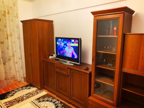 een tv op een houten kast bij Xata 1+2 in Alma-Ata
