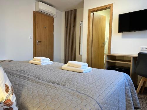 a bedroom with a bed with two towels on it at Penzion U Halmů in Hustopeče