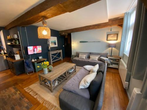 sala de estar con sofá y mesa en La Cabane du Pecheur, en Honfleur