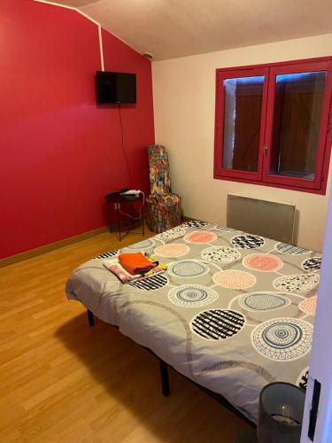 a bedroom with a bed in a room with a red wall at Chambre privée dammarie les lys in Dammarie-lès-Lys