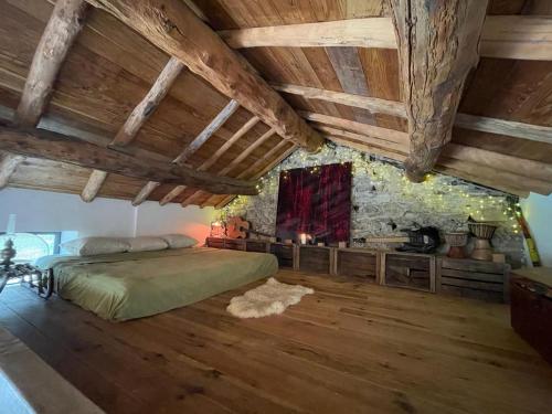 um quarto com uma cama e uma parede de pedra em Mas Montet chez Raphael em Valleraugue