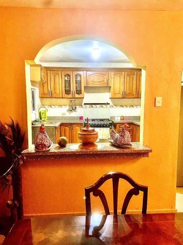 cocina con armarios de madera, mesa y silla en Buena ventura house en San Luis