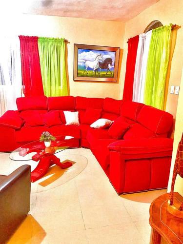 una sala de estar roja con un sofá rojo en una habitación en Buena ventura house en San Luis