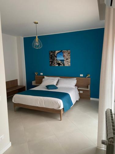 a blue bedroom with a bed with a blue wall at Maqueda Suites in Palermo