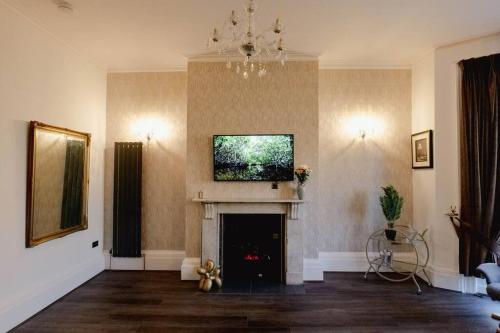 a living room with a fireplace with a tv above it at Stunning flat in Brighton & Hove - Central luxury. in Brighton & Hove