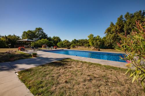 a swimming pool in the middle of a yard at Domaine de Laplan in Cézan