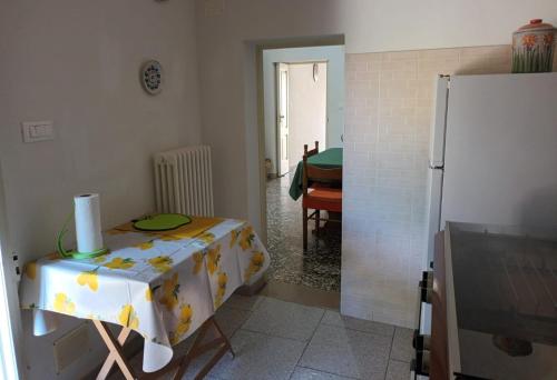 a kitchen with a table and a refrigerator at Casa Teresina in Cannole