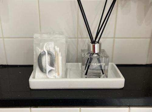 a black counter top with a vase with sticks in it at Studio flat in the heart of St. Johns Wood in London