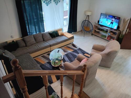 a living room with a couch and chairs and a tv at Holiday home Ivano in Korenica