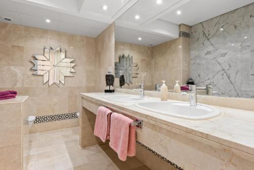 a bathroom with two sinks and a large mirror at Beachside Luxury Apartment in Puerto Banus - Club Playas del Duque in Marbella
