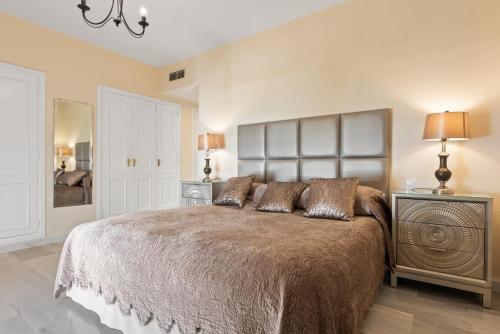 a bedroom with a large bed with pillows on it at Beachside Luxury Apartment in Puerto Banus - Club Playas del Duque in Marbella