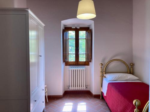 - une petite chambre avec un lit et une fenêtre dans l'établissement Agriturismo Podere Filicaia, à San Giovanni Valdarno