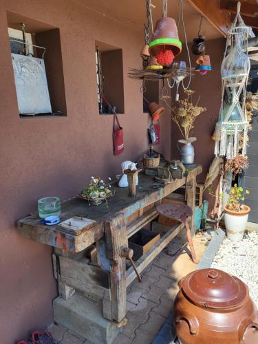 une table en bois avec des pots et des vases sur un mur dans l'établissement Chambre au tonneau, à Fleurie