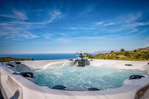 a plunge pool with the ocean in the background at Villa Stone Walls with Jacuzzi in Castellammare del Golfo
