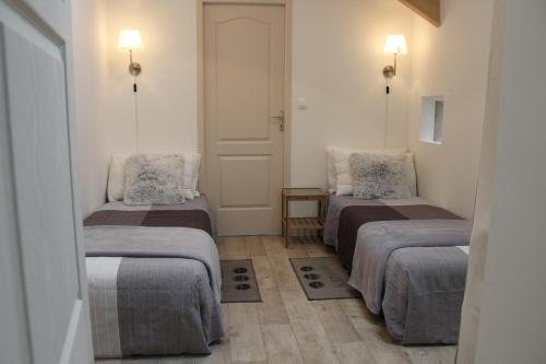 two beds in a small room with two lamps at Le Poirier Perfect for 2 adults and 2 children Heated Pool and Games Room in Auverse