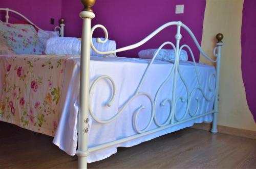 a white bed in a bedroom with purple walls at Villa Niki in Págoi