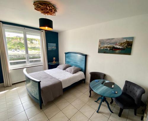 een slaapkamer met een bed, een bureau en een tafel bij L’Escapade de Michel - Vue Mer - Élégant in Dieppe