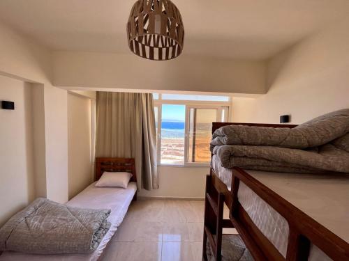 a bedroom with two beds and a window at Tree House Dahab in Dahab