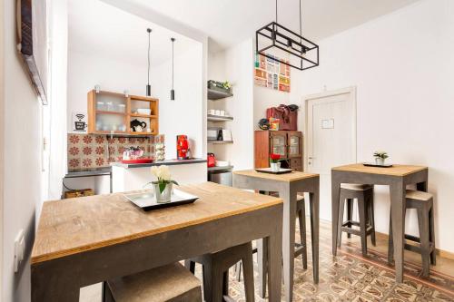 a kitchen with a table and two stools at Binario 91 Rooms in Palermo