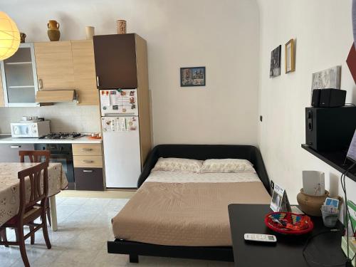 a bedroom with a bed and a kitchen with a refrigerator at Piero's Home in Castellana Grotte