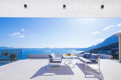 a patio with a table and chairs on a balcony at Villa Ble in Katávolos