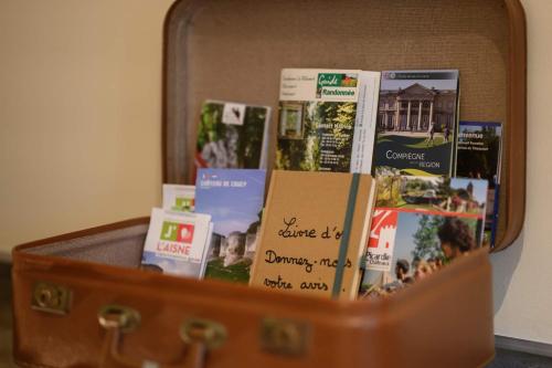 a suitcase filled with books and magazines on it at gîte Cosy Green 2 in Chevincourt