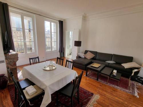 un salon avec une table et un canapé dans l'établissement Appartement lumineux Art-déco centre-ville parking, à Bordeaux