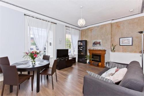 een woonkamer met een bank, een tafel en een tv bij 1 Bedrooms Flat in Central Edinburgh Haymarket, Heart of Edinburgh Flat Sleeps 4 , in Edinburgh