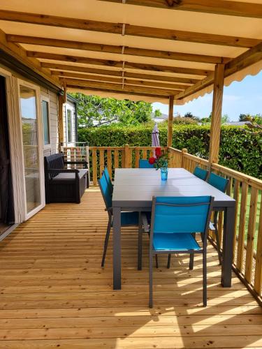 une terrasse en bois avec une table et des chaises dessus dans l'établissement Mobil-home à Lattes, à Lattes