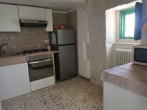 a kitchen with a refrigerator and a stove top oven at Trullo Le Tre Sorelle in Cisternino