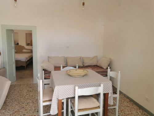 a dining room with a table and a couch at Trullo Le Tre Sorelle in Cisternino