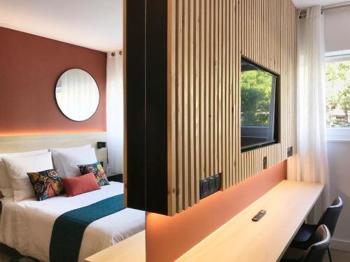 a bedroom with a bed and a desk with a mirror at Studio Chic Croix-Barbieux in Croix