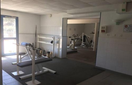 - une salle de sport avec plusieurs tapis de course et machines dans l'établissement MARINA SUR L'ILE DES PECHEURS AVEC COMPLEXE AQUATIQUE, au Barcarès