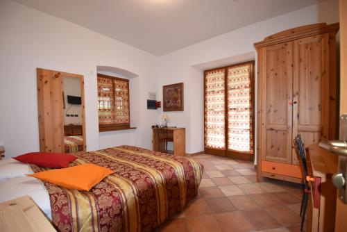 a bedroom with a bed with an orange pillow on it at RAINBOW in Rovereto