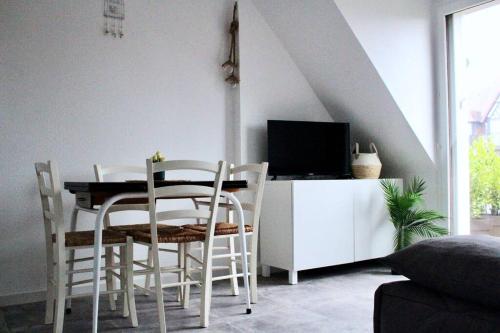 uma sala de jantar com mesa e cadeiras em Cabourg, appartement T2 accès direct mer em Cabourg