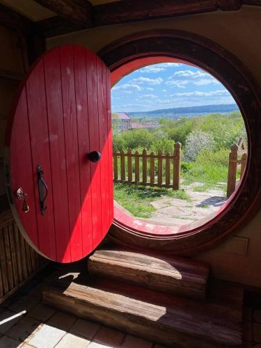 a red door with a round window in a room at Едем in Brzezhany