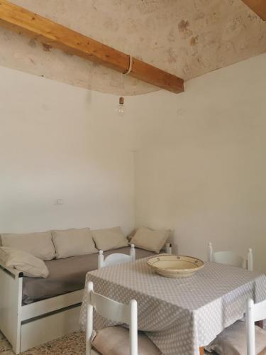 a living room with a table and a couch at Trullo Le Tre Sorelle in Cisternino