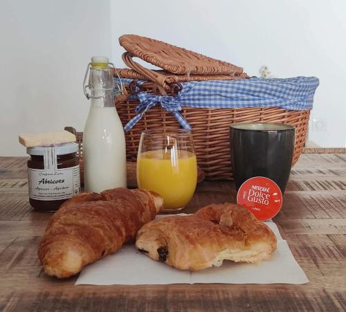 Les Logis de Cocagne في سان ريمي دو بروفنس: طاولة مغطاة بالمعجنات وسلة من الحليب