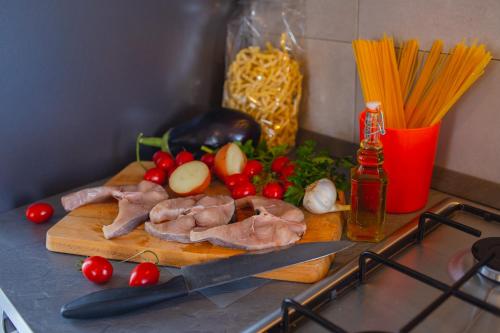 a cutting board with meat and vegetables and a knife at !!! 2 MIN DALLA SPIAGGIA !!! - Casa Bentivegna in Sciacca