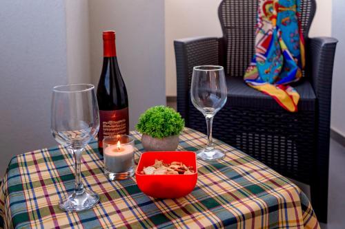 a table with a bottle of wine and two wine glasses at !!! 2 MIN DALLA SPIAGGIA !!! - Casa Bentivegna in Sciacca