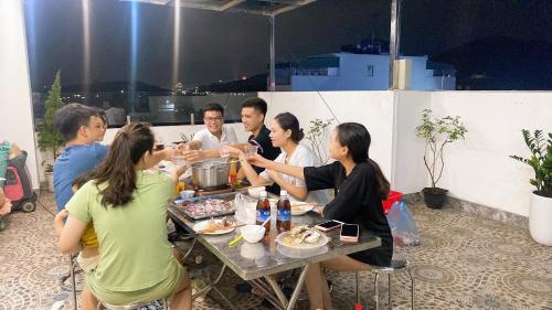 een groep mensen die rond een tafel eten bij Kim Ngan Ha Long Hotel in Ha Long