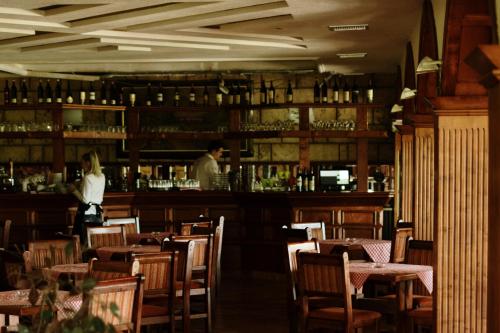 a woman standing at a bar in a restaurant at Hotel Etno Centar Balasevic in Boljevac