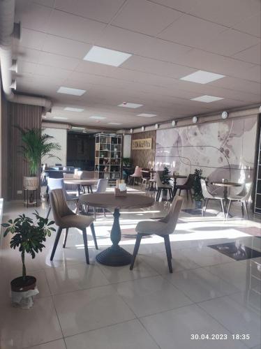 a room with chairs and tables and a table and chairs at Apart-hotel 24/7 in Kamianets-Podilskyi