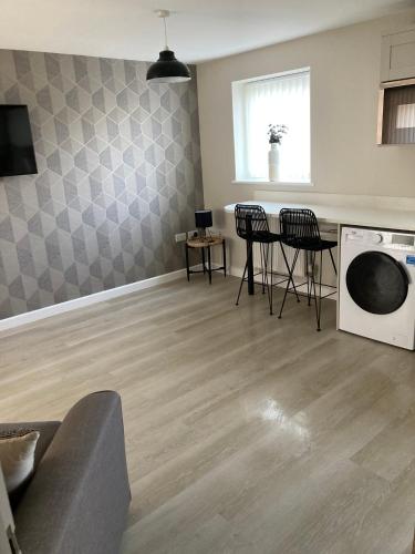 a living room with a table and chairs and a microwave at Chapel Court Apartments in Cannock