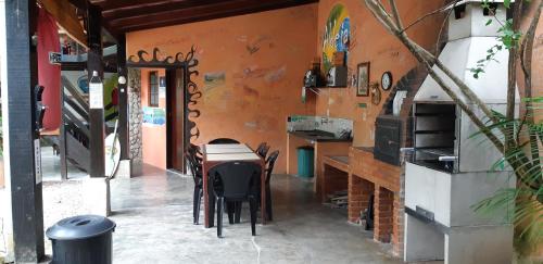 a room with a table and chairs in a building at Aldeia Itamambuca Chalé Camping Ubatuba in Ubatuba