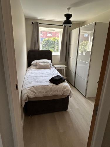 a small bedroom with a bed and a window at Chapel Court Apartments in Cannock