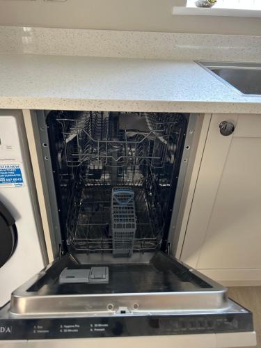 an dishwasher with its door open in a kitchen at Chapel Court Apartments in Cannock