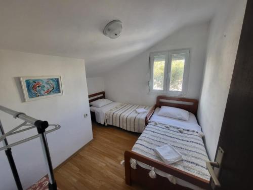 una habitación con dos camas y una ventana en Apartman Leona, en Rogoznica