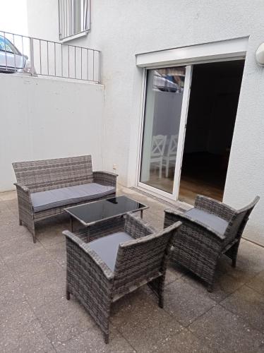 patio z 3 wiklinowymi krzesłami i stołem w obiekcie Volkach am Main w mieście Volkach