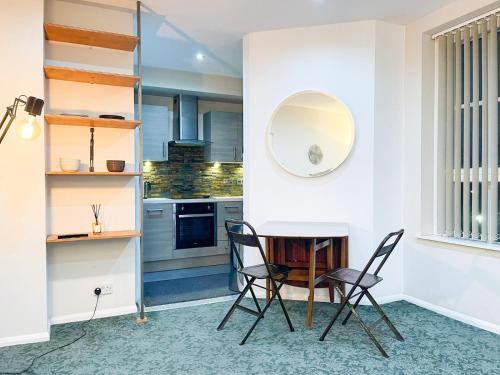 uma cozinha com mesa e cadeiras num quarto em Wilmot Guest House em Londres